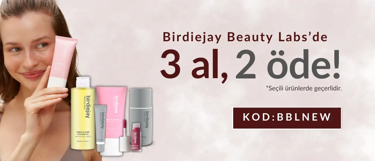 Bir kadın, birdiejay beauty labs cilt bakım ürününün pembe tüpünü tutuyor, markanın diğer ürünleri yakında sergileniyor.