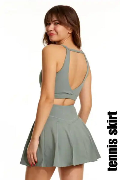 Ada yeşili tenis eteği ve spor sütyeni takımı.