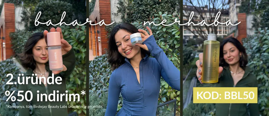 Gümüş kapaklı ve minimalist tasarımlı şık, silindirik pembe bir şişe.