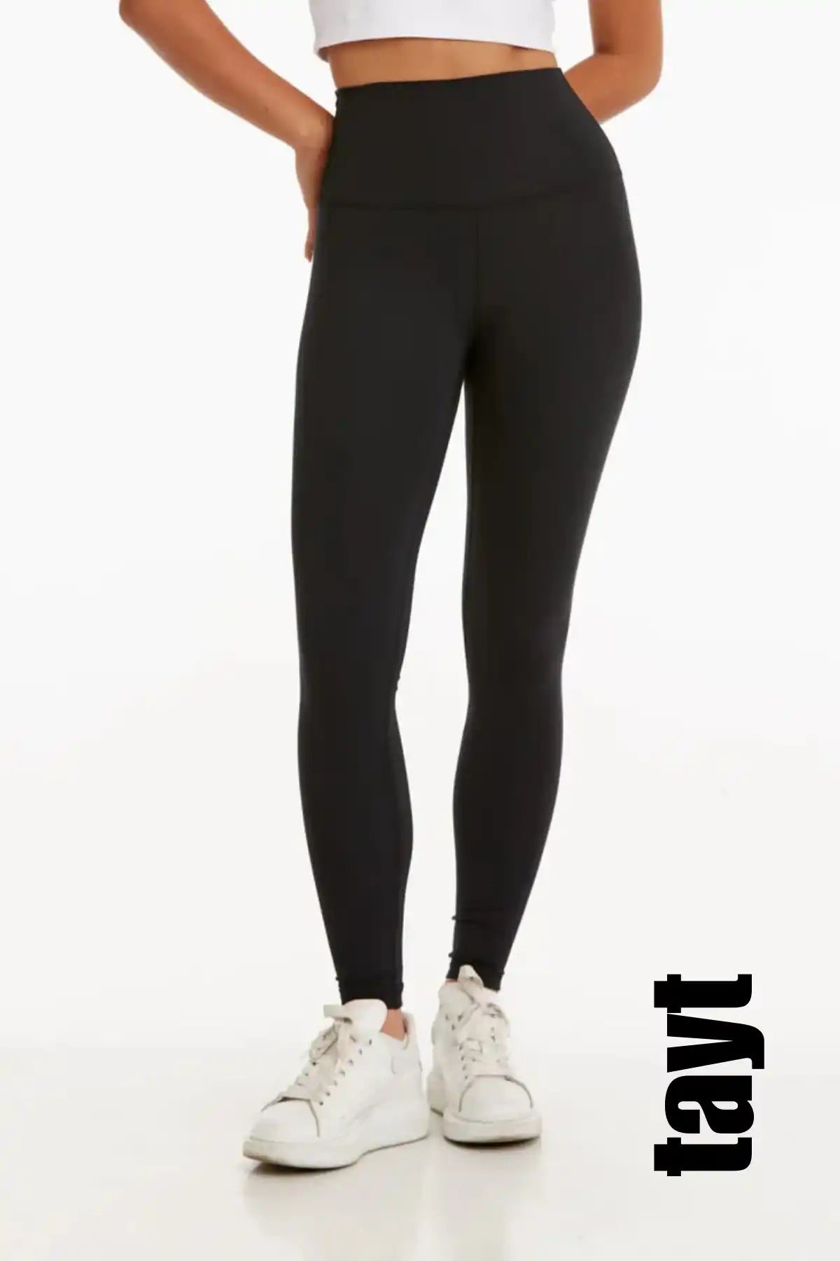 Beyaz spor ayakkabılarla birleştirilmiş siyah yüksek bel atletik tayt.