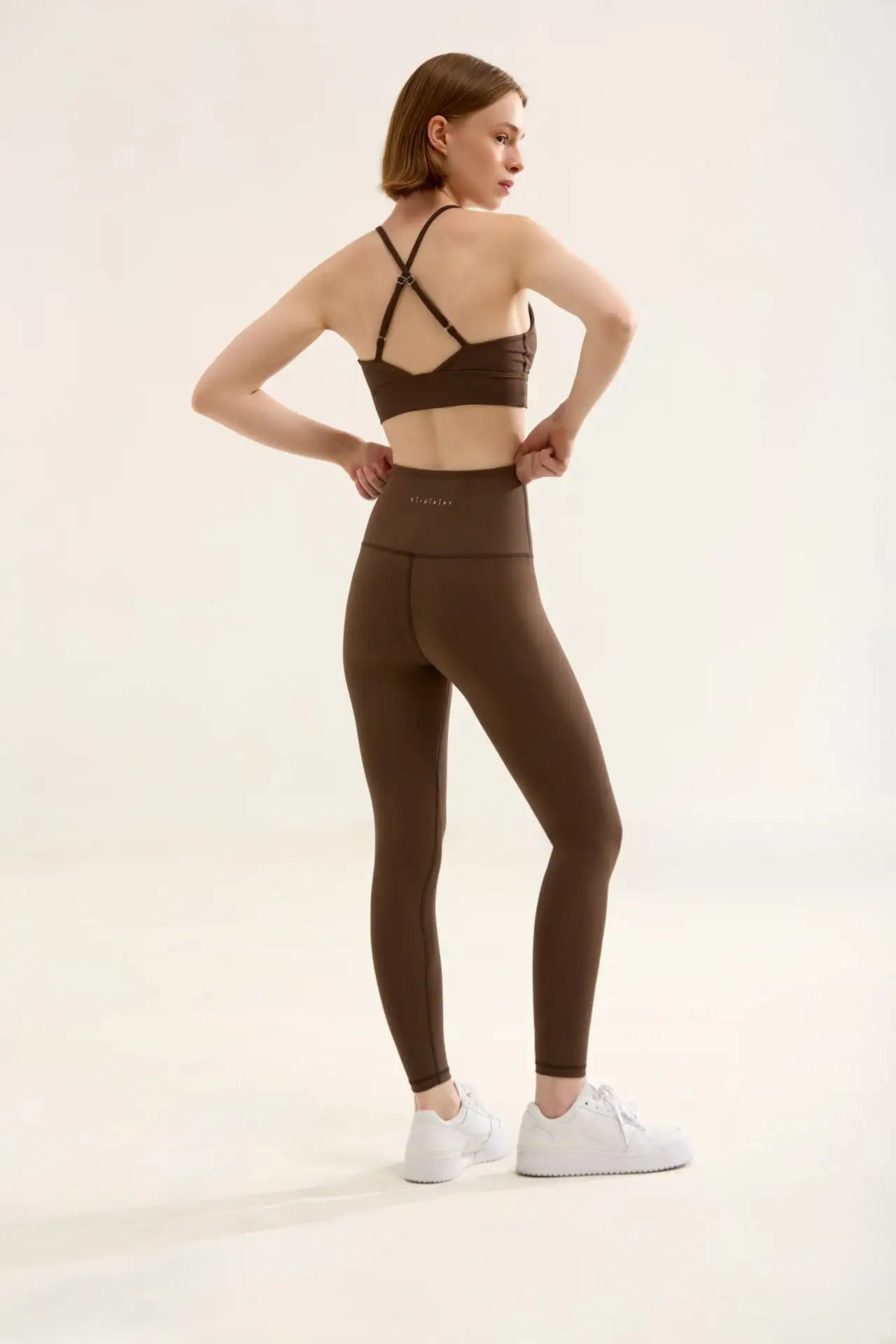 Yüksek bel ve kaburgalı dokulu kahverengi tayt, muhtemelen spandeks veya benzeri malzemeden yapılmış.